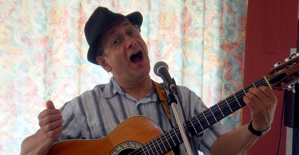 Francis Weill chante avec sa guitare